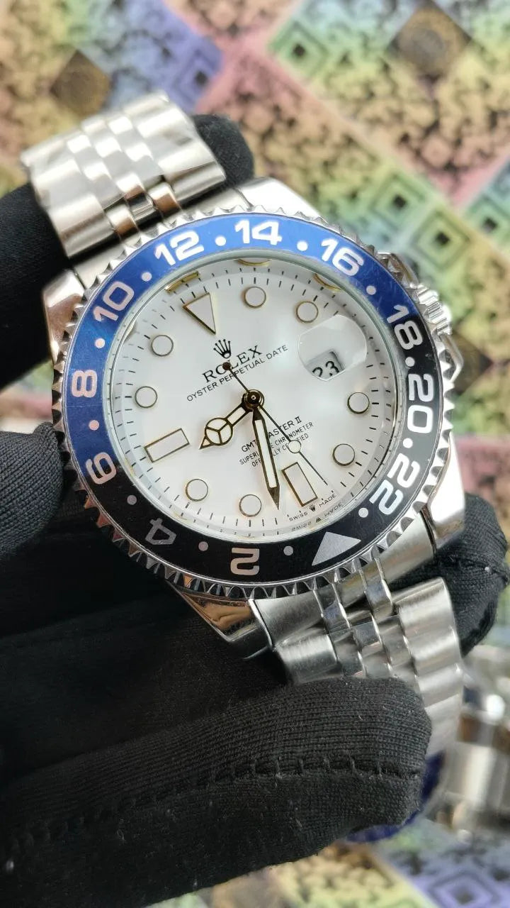 Silver watch with blue and black bezel on a colorful mosaic background