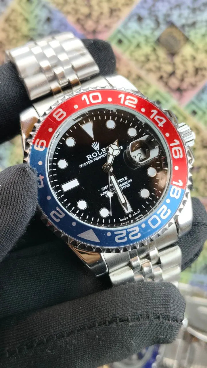 Rolex watch with a distinctive black, red, and blue bezel on a textured surface.