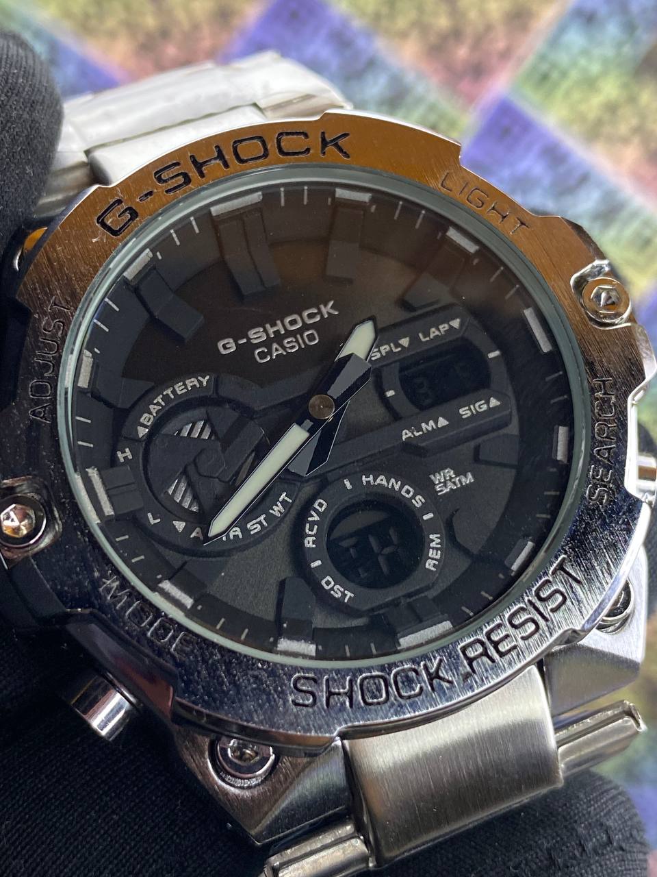 G-Shock Casio watch with metallic band on a colorful background