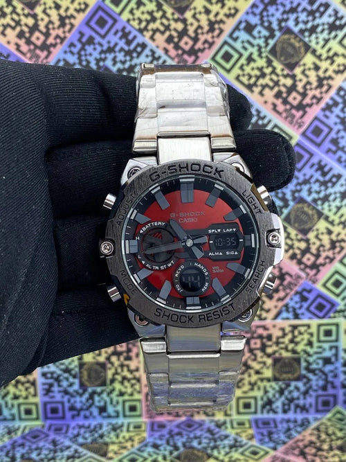 G-Shock watch held by a gloved hand against a colorful geometric pattern background