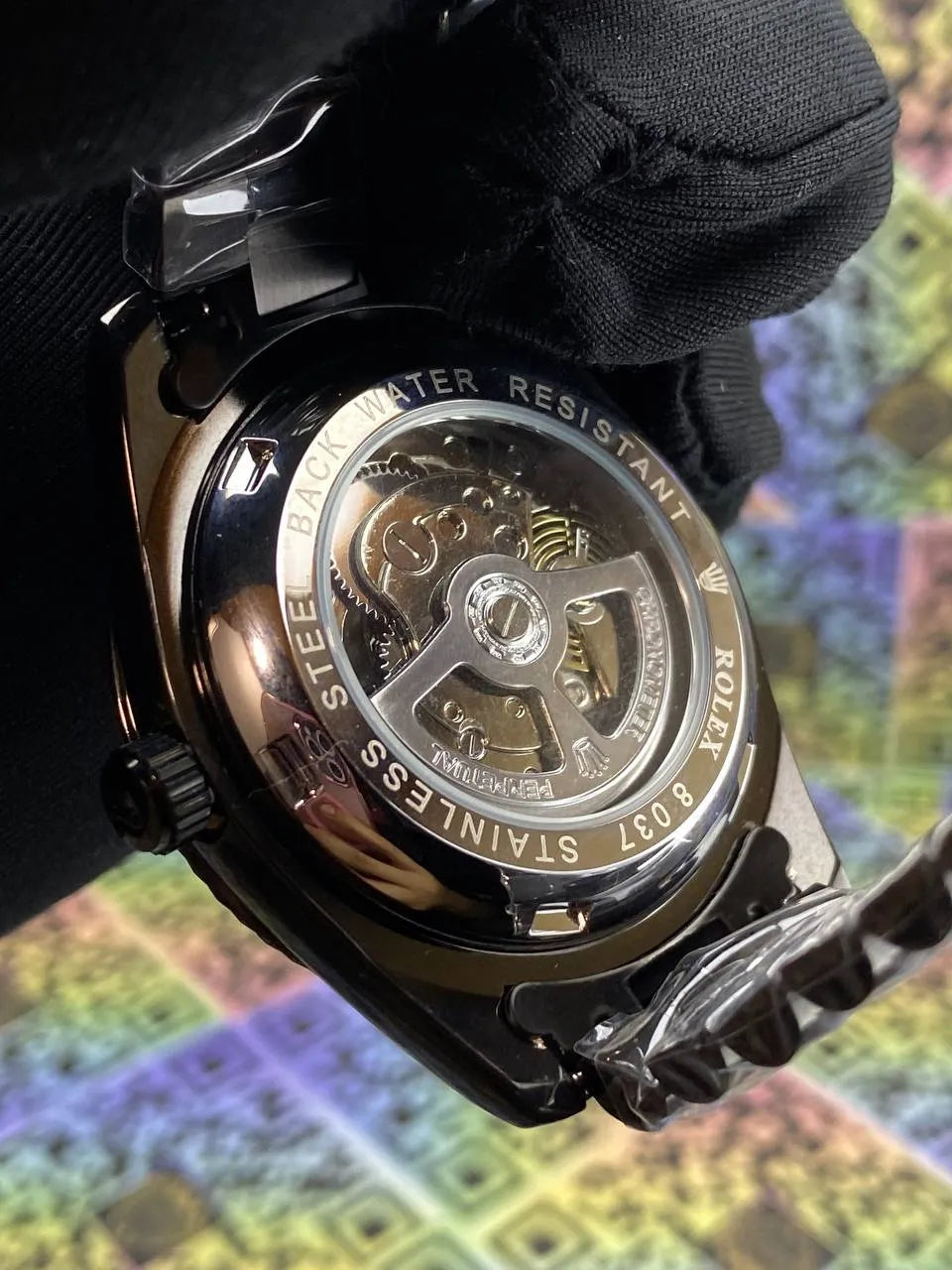 Close-up of a mechanical watch with intricate details on a colorful abstract background