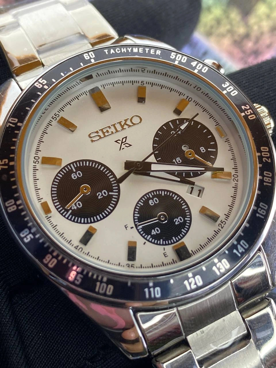 Seiko watch with a detailed face and metal band on a dark background