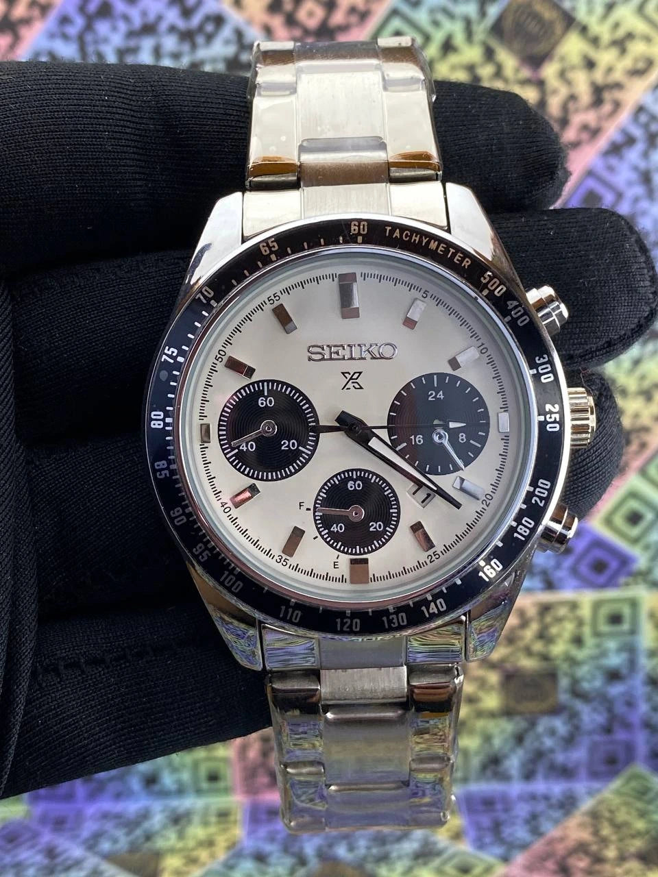 Seiko watch with silver metal strap on a colorful abstract background