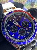 Wristwatch with a blue face and silver case on a dark background